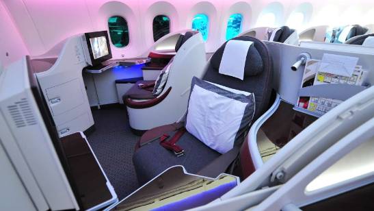 private jet interior, satisfied, a hostess serving champagne, photorealistic, elegant ambiance with minimalist design and plush carpeting, highly detailed, glasses clinking, high dynamic range, neutral colors, recessed ceiling lights, shot with an 85mm lens.